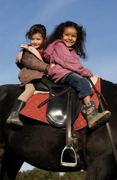 Twee kleine meisjes rijden — Stockfoto