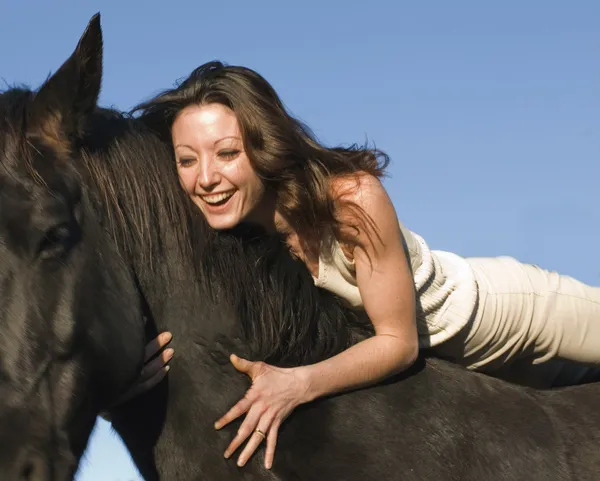 Laughing woman and stallion — Stock Photo, Image