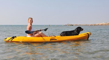 Woman and dog on a kayak clipart