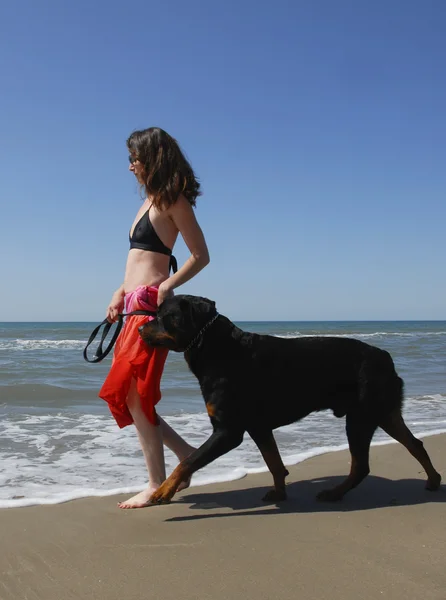 Mulher e rottweiler na praia — Fotografia de Stock