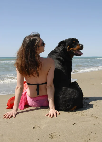 Kadın onun rottweiler ile sahilde — Stok fotoğraf