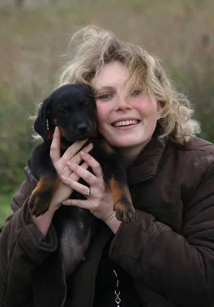 Puppy beauceron and woman — Stock Photo, Image