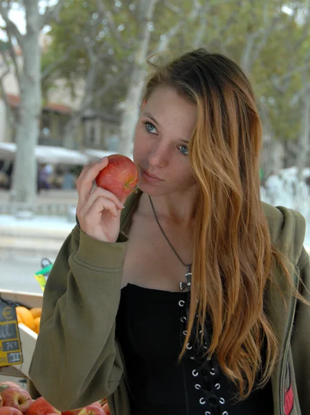 Ung kvinna luktar en frukt — Stockfoto