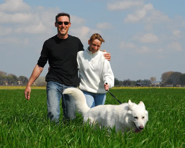Couple and white german shepherd — Stock Photo, Image