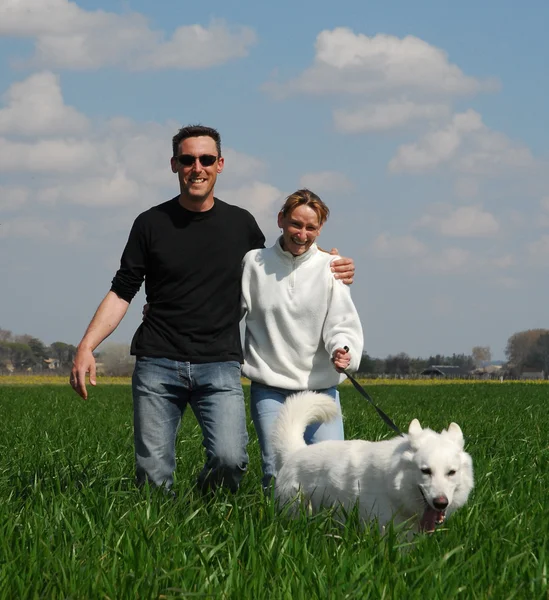 Couple and white german shepherd — Stock Photo, Image