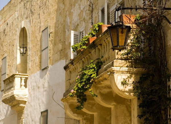 A medieval limestone balcony in traditional baroque style in Mdina on the island of Malta