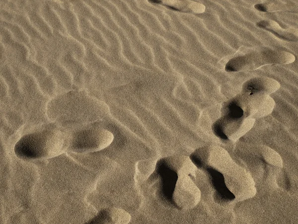 Voetstappen in het zand — Stockfoto