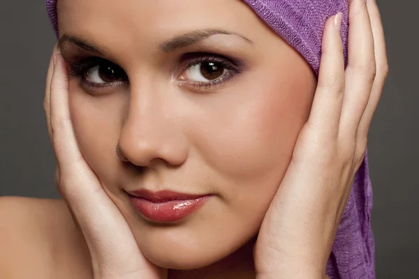Mooie brunette in een violet sjaal — Stockfoto