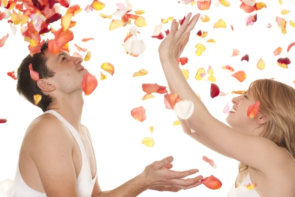 El hombre y la mujer con pétalos de rosas — Foto de Stock