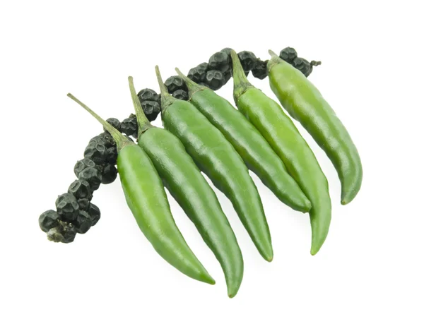 Green pepper and a black pepper — Stock Photo, Image