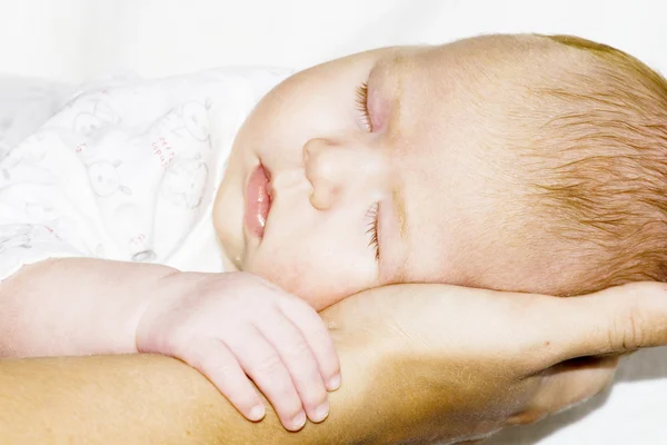 Dormir bébé sur une mère mains — Photo