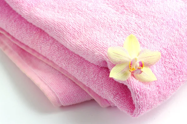 Flor de orquídea en toalla de spa — Foto de Stock