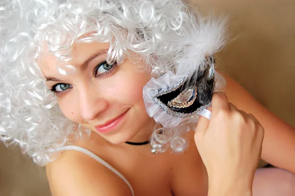 Beautiful girl in white twig holding mask — Stock Photo, Image