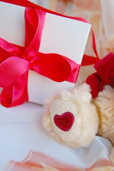 Συσκευασία δώρου, με κόκκινο φιόγκο, teddy αρκούδα πόδι — Φωτογραφία Αρχείου