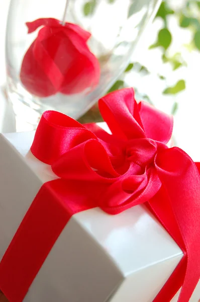 Коробка подарков и красная роза — стоковое фото