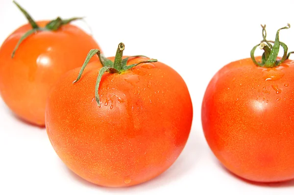 Tre pomodori rossi maturi con estremità verdi isolate su bianco — Foto Stock