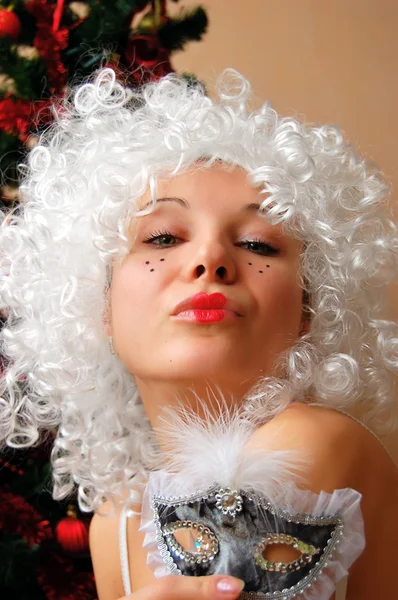 Menina bonita em branco galho segurando máscara — Fotografia de Stock