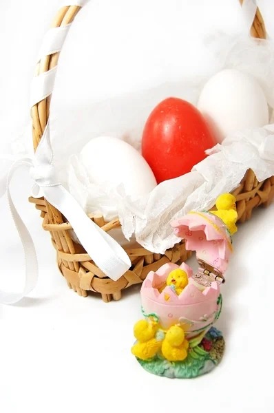 Korb mit roten und weißen Eiern und Hühnerfiguren — Stockfoto