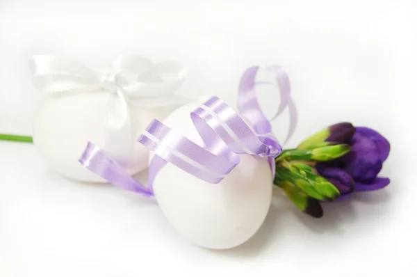 Eier mit Schleife und Frühlingsblumen — Stockfoto