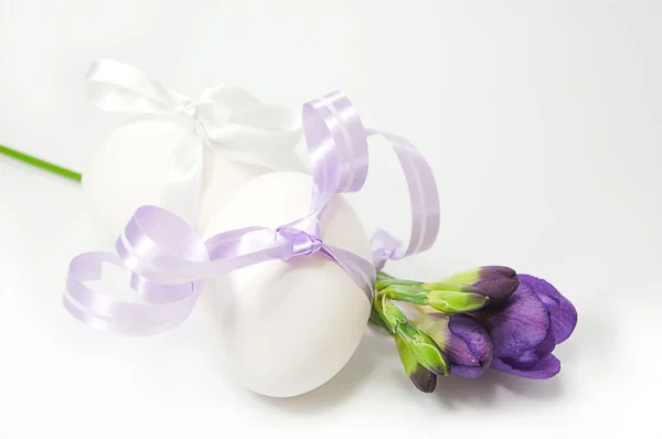 Ovos com fita e flores de primavera — Fotografia de Stock