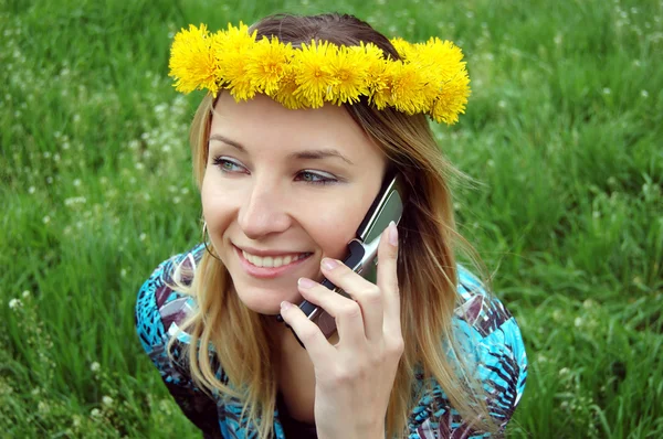 Rubia chica feliz con diente de león diadema hablando en el móvil — Foto de Stock