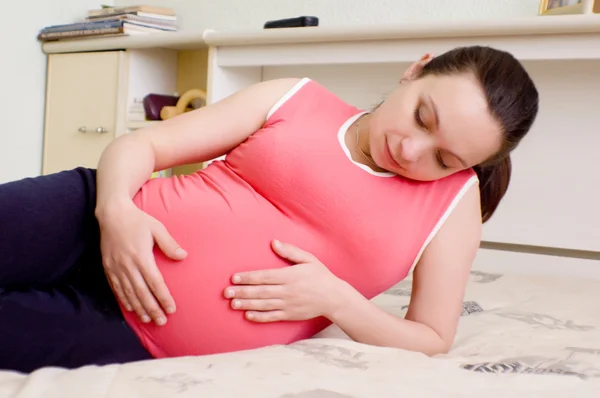 Mulher grávida deitada na cama — Fotografia de Stock
