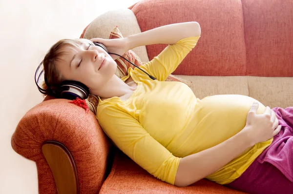 Terhes nő fülhallgatóval Stock Kép