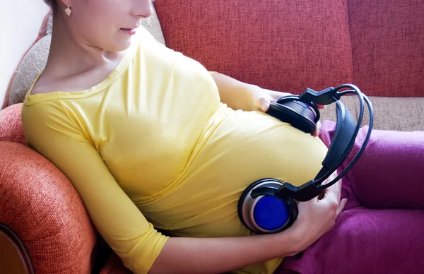 Zwangere vrouw en muziek Stockfoto