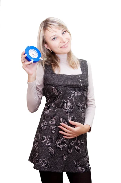 Беременная женщина держит часы — стоковое фото