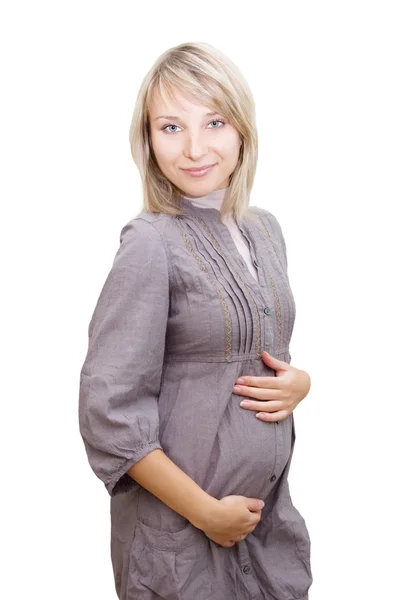 Улыбающаяся беременная женщина в сером платье — стоковое фото