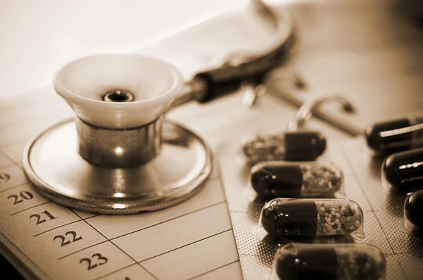 Стетоскоп і таблетки над блокнотом — стокове фото