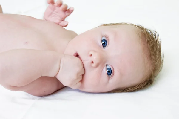 Adorável menino de olhos azuis deitado — Fotografia de Stock