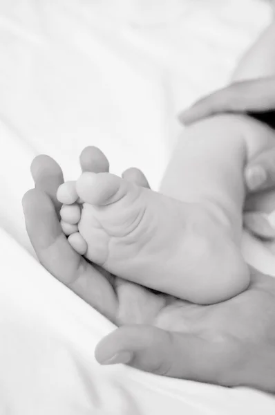 Mujer mano sostiene bebé pierna —  Fotos de Stock