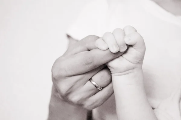 Bebé sostiene dedo madre — Foto de Stock