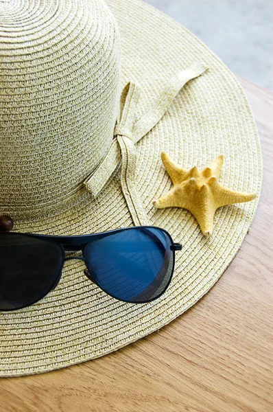 Hut, Sonnenbrille und Muscheln — Stockfoto
