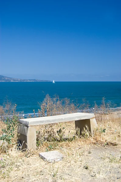 stock image Empty bench looking onto the sea