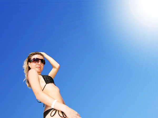 Vrouw in bikini tegen felle zon — Stockfoto