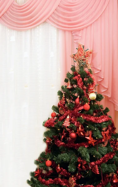 Χριστουγεννιάτικο δέντρο σε ένα δωμάτιο δίπλα στο παράθυρο — Φωτογραφία Αρχείου
