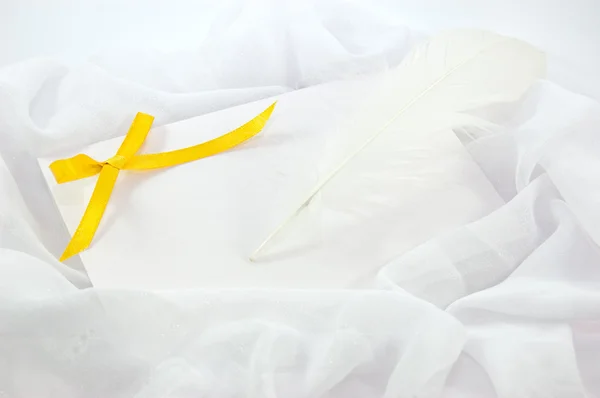 Nota en blanco, cinta amarilla y pluma — Foto de Stock