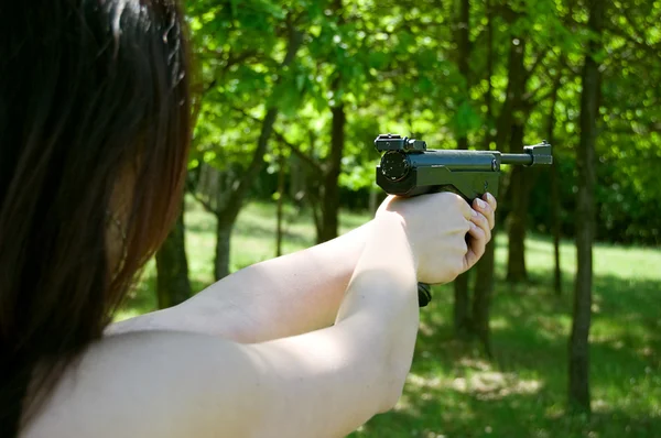 Woman's hand aiming pneumatic gun — Stock Photo, Image