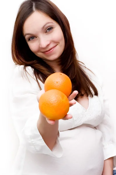 Беременная женщина и апельсины — стоковое фото