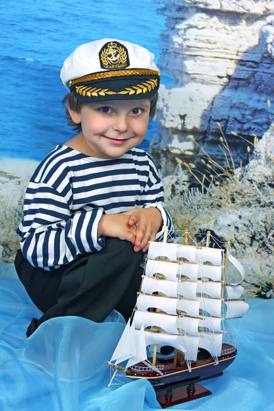 De jongen in de zee met de Marine jurk — Stockfoto