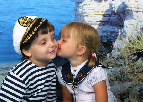 海洋のドレスで、少年にキスの女の子 — ストック写真