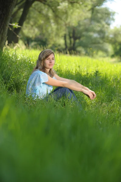 Jeune fille assise dans l'herbe haute — Photo