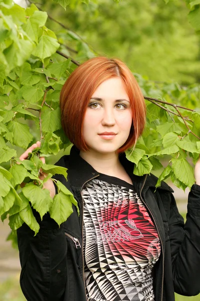 Menina bonita nos ramos verdes — Fotografia de Stock