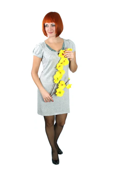 Girl in a gray dress with a yellow flowe — Stock Photo, Image