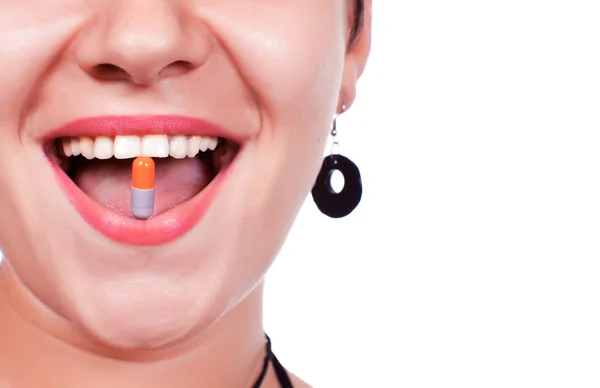 Sonriendo con la píldora en la boca — Foto de Stock