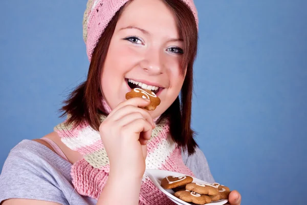 Sorridente ragazza mangiare un biscotto — Foto Stock