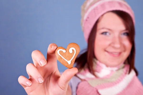 Chica sosteniendo una galleta corazón — Foto de Stock
