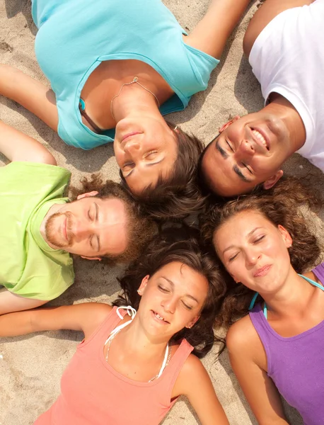 Teenager liegen im Kreis am Strand — Stockfoto